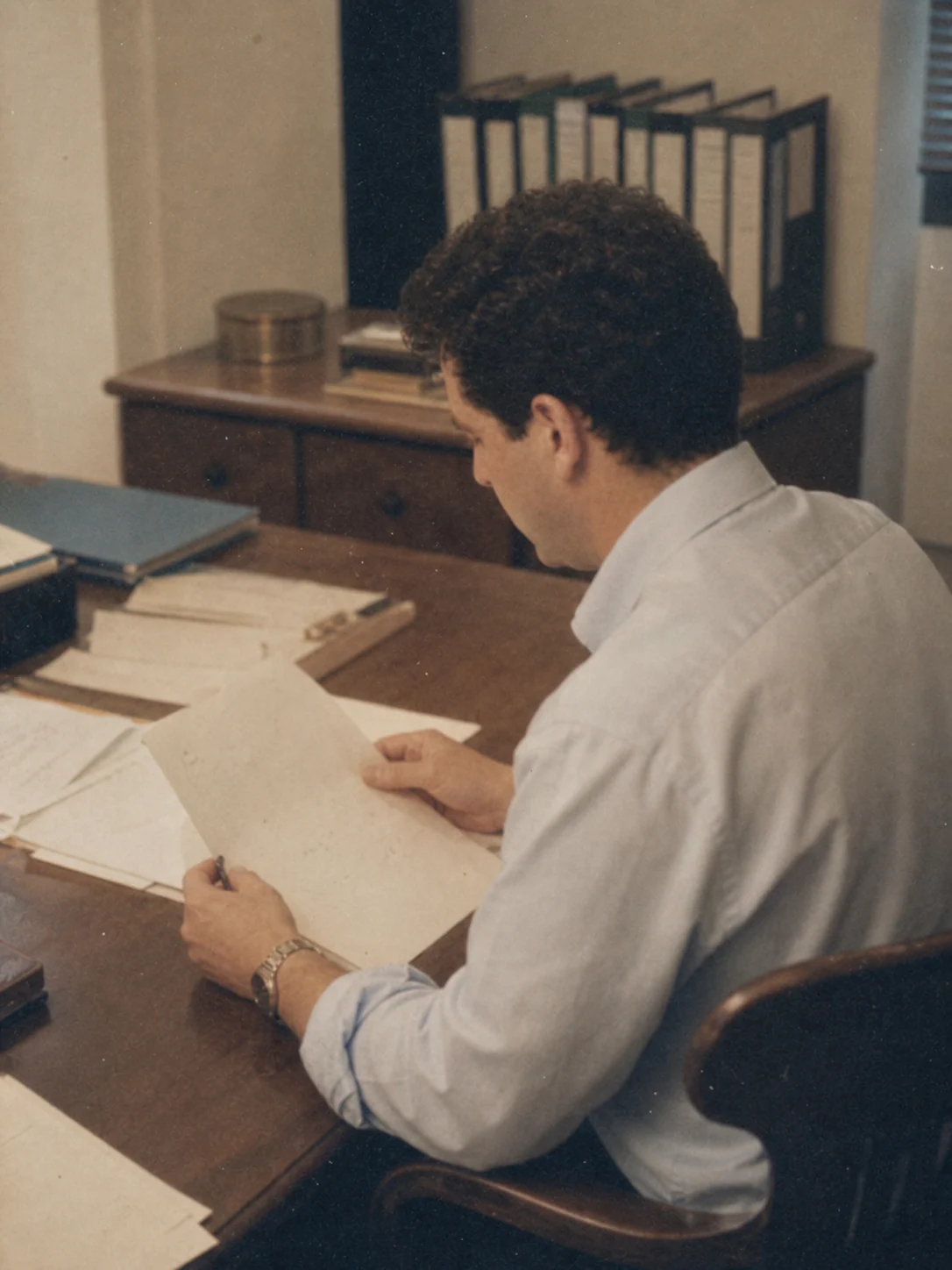 SIRO founder reviewing documents at his desk in 1999.