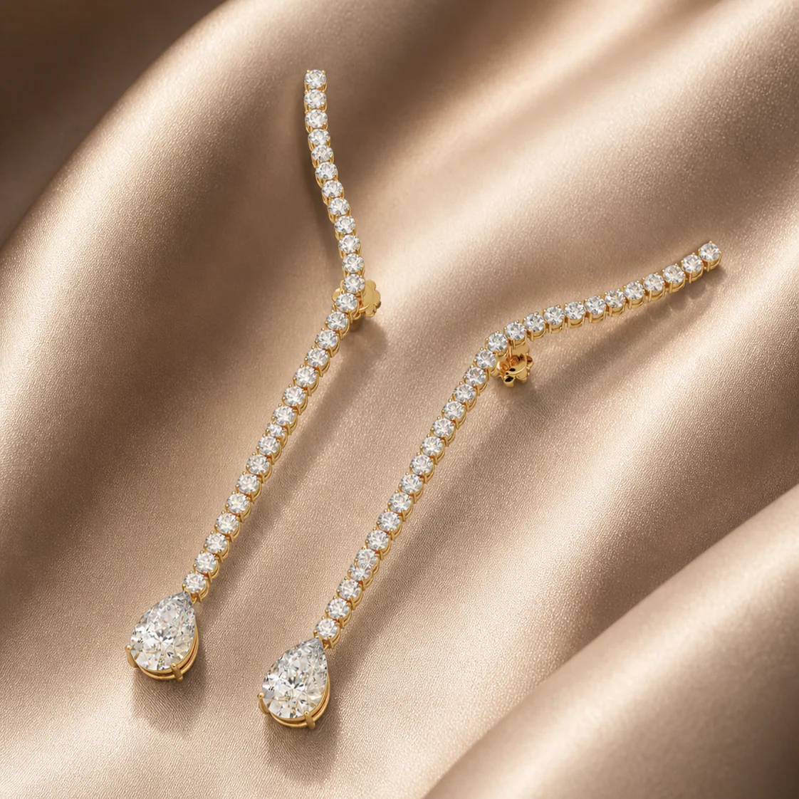 Elongated diamond drop earrings with pear-shaped accents on satin