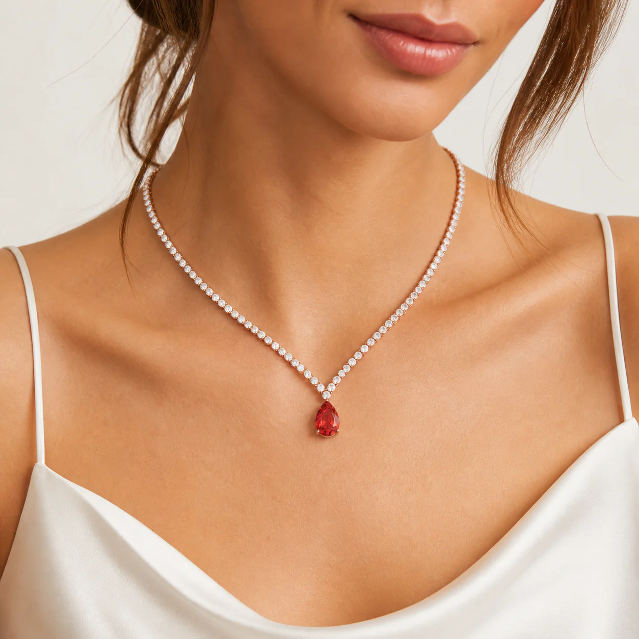 Red drop necklace with a luminous line of white stones worn on the neckline